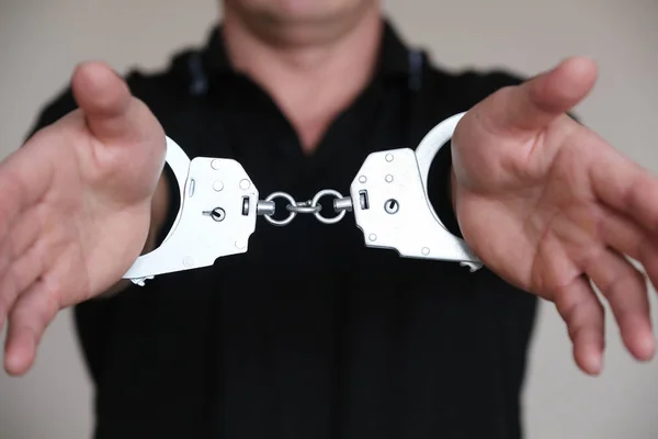 The man at the police station. Handcuffs on the wrists of the detained man. — Stock Photo, Image