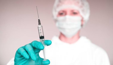 Doktor virüsü hastaya aşı koyar. Salgın koruma. Koruyucu maske yüzünde. Gözlük. Koruyucu elbise.