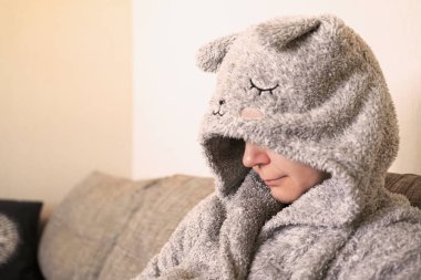 Stres depresyon. Duygu üzüntü. Yakın çekim gergin endişeli bir ifade ile üzgün bir genç güzel kadın portresi, başını bir bornoz bakıyordu kapalı.