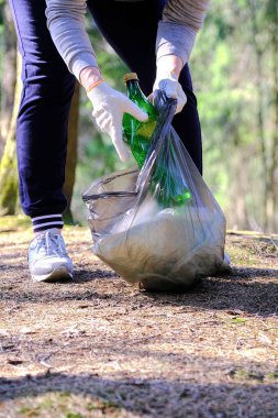 The girl collects garbage. Puts it in the garbage bag. The problem of environmental pollution. Ecological pollution. Problem of ecology.