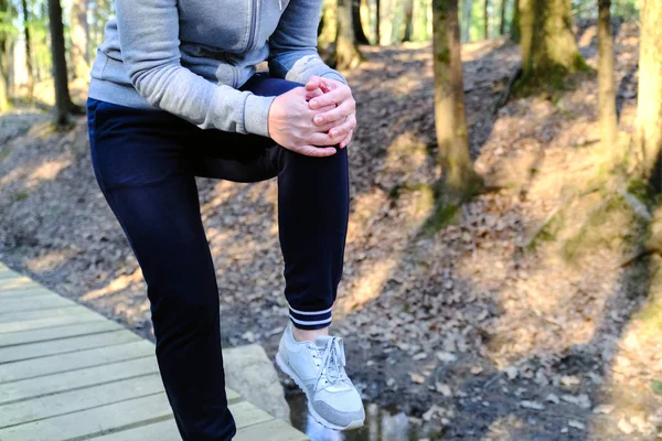 Sports injury. Woman with pain in knee while jogging.