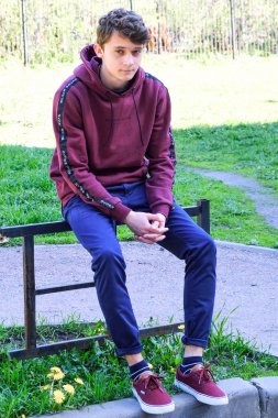 Genç adam uzaklara bakıyor. Dışarıda düşünen genç bir adam. Merdivenlerde oturup, mesafeye bakıyorum, sanırım..