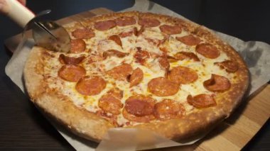 Sosisli çıtır çıtır sıcak taze pizza. Çok lezzetli. Bir pizza kesici.