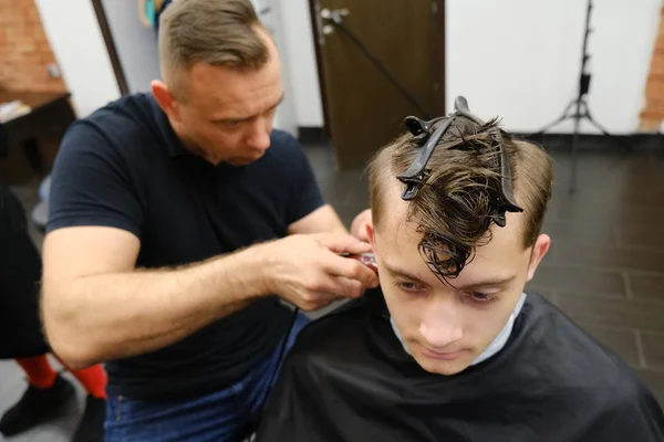 Maître des coupes de cheveux au travail. gars heureux se faire couper les cheveux par coiffeur . — Photo