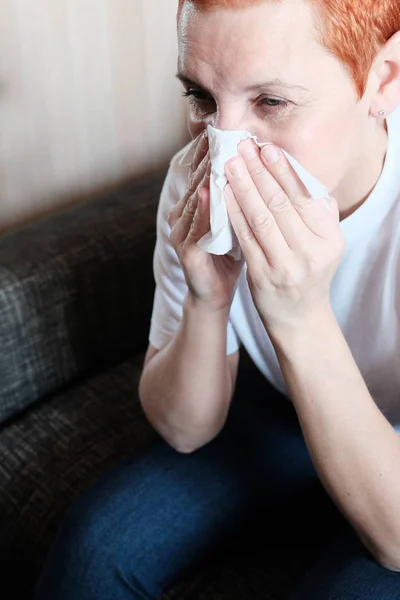 Flickan lider av allergier. Han sätter en pappersservett till näsan. Klåda och nysningar. Irritation i nässlemhinnan. — Stockfoto