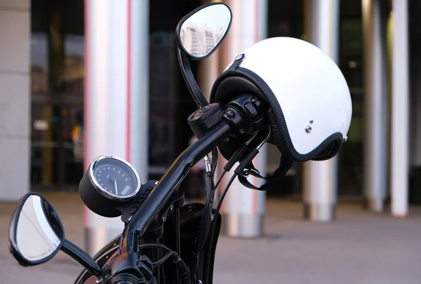 Przepustnica i hamulec na kierownicy motocykla z chromowanym i białym hełmem bez osłony. Biały hełm wiszący na uchwycie motocykla. — Zdjęcie stockowe