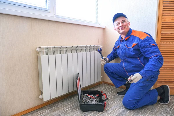 Male plumber fixes a leak. The adjustable wrench tighten the nut clamps seals, isolates. — Stock Photo, Image