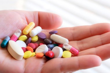 Biyolojik olarak aktif katkı maddesi. Elinde bir avuç hap var. Gölge üretiminin farmakolojisi. Plasebo. Sahte ilaç sorunu.