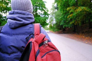 Kız Turist. Yoldan geçen bir arabayı beklerken yolda dikiliyor.