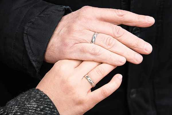 Gifteringer på hendene. Et eldre par giftet seg. Lykkelig familie. Familie utendørs. – stockfoto