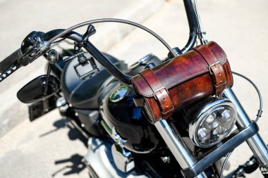 Direksiyon ve farlar yakın plan. Direksiyonda kahverengi deri çantalı motosiklet helikopteri..