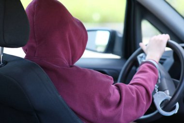 Suçlu bir araba çalarken yakalandı. Hava korsanı direksiyona kelepçelenmiş. Polis iyi iş çıkardı.