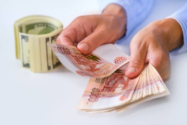 Döviz bürosunda döviz bozduran kız. Masada yüz dolarlık banknotlar var..