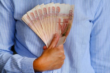 Finansör elinde bir tomar banknot tutuyor. Kredileri faiziyle ve taksitle teklif etmek.