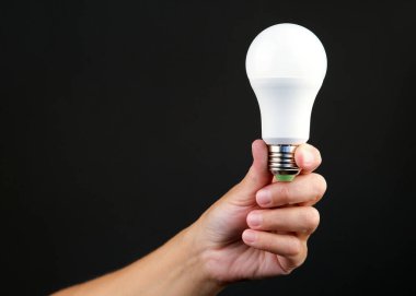 Bir insanın elinde enerji tasarrufu ampulü vardı. Modern ekonomik aydınlatma kavramı