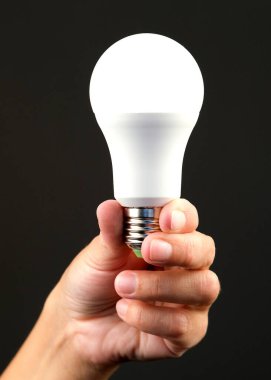 Bir insanın elinde enerji tasarrufu ampulü vardı. Modern ekonomik aydınlatma kavramı