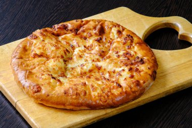Kesme tahtasında Gürcü Khachapuri Mergoli. Ulusal peynirli tortilla. Kızarmış lezzetli kabuk. Sağlıklı beslenme kavramı
