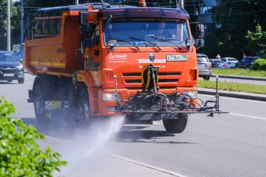Su makinesi. Güçlü bir su akıntısı kaldırıma doğru yönelir. Kamyon yol yüzeyini yıkıyor.