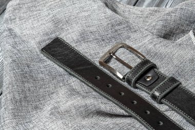 Masanın üzerinde el yapımı hakiki bir deri kemer var. Deri aksesuar tasarımı için bir şablon. Arka plan, parlak metal kemer tokası. Soyut arkaplan. Desenli arkaplan.