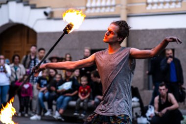 Yoldan geçenler sokak ateşi gösterisinin izleyicileri oldular. Genç bir adam elinde ışıklarla bir sopa tutuyor. Saint-Petersburg 'da. - Rusya. 1 Ekim 2020