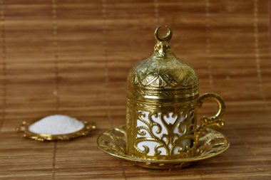 Hafif bir arka planda kahve için altın bardak