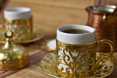 Hafif bir arka planda kahve için altın bardak