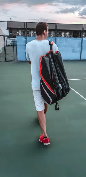 man with a tennis bag on the court