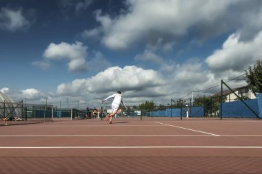 Sahada tenis oynayan adam
