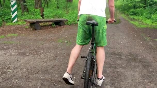 Kirli Yeşil Şort Bisikletçi Ormandaki Bir Islak Çamurlu Yolda Yağmur — Stok video