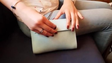 Kırmızı manikür kızla beyaz bir smartphone çeker bir mavi deri çanta, yakın çekim, ağır çekim