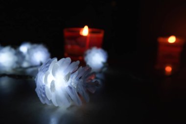 Noel ve yeni yıl arka plan, mumlar ve koniler, yakın çekim, siyah arka plan şeklinde garland