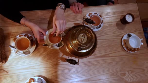 ロシア ケトル サモワール ベーグルと伝統的なロシア サモワールから沸騰醸造お茶を注ぐ人々 古い銅サモワールから紅茶を注ぐ — ストック動画