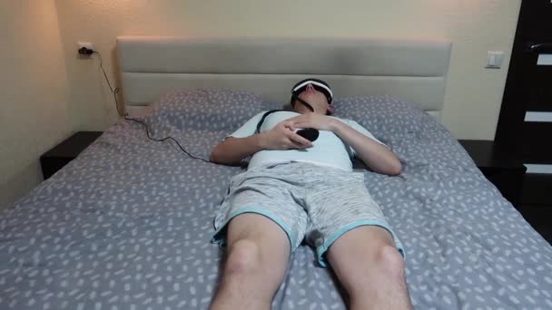 Młody Atrakcyjny Mężczyzna Używa Urządzenie Masażu Oczu Leżąc Łóżku Trzymając — Wideo stockowe