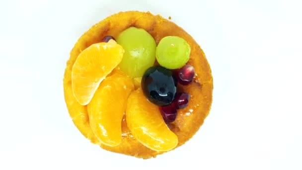 新鮮な果物と果実白い背景に チーズケーキ オレンジ ブドウ ザクロ 上面に果実の部分でチーズケーキ — ストック動画