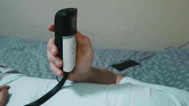 Young Attractive Man Uses Eye Massager Device Lying Bed Holding — Stock Video