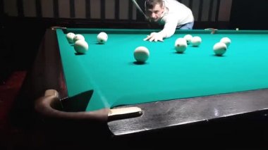 yakışıklı delikanlı bir bilardo topu cebine koyar.