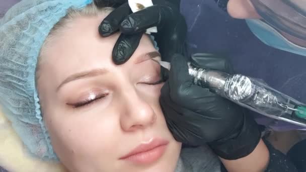 美容师女性在眉毛上应用永久性妆 在美容院的美丽模特身上纹上眉毛 — 图库视频影像