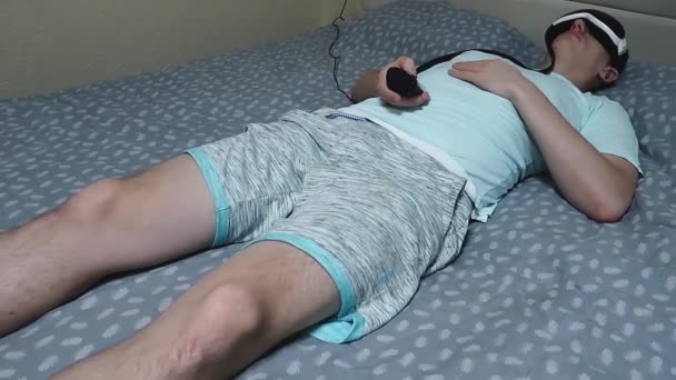 Young Attractive Man Uses Eye Massager Device Lying Bed Holding — Stock Video