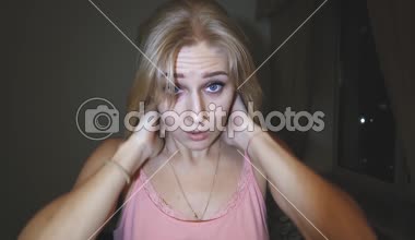 sarışın bir genç güzel kadın parlak mavi gözlü uzun saçları düzeltiyor, saçları ile çalış ve kameraya doğru görünüyor