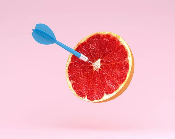 Greyfurt dilim, daire ile meyve pastel pembe background.minimal fikir gıda ve meyve kavramı üzerinde işaretli ve mavi dart hedef. Fikir yaratıcı iş ve pazarlama iletişimi reklam üretir