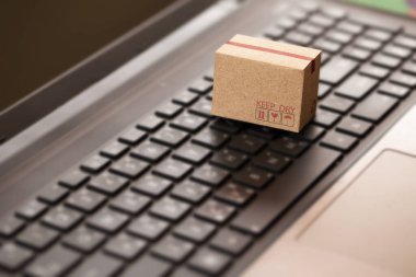 Defter klavyesinde karton kutu. Çevrimiçi alışveriş, e-ticaret ve teslimat hizmeti konsepti. Üretim hizmeti ve tüketicilere internet üzerinden ulaşım.