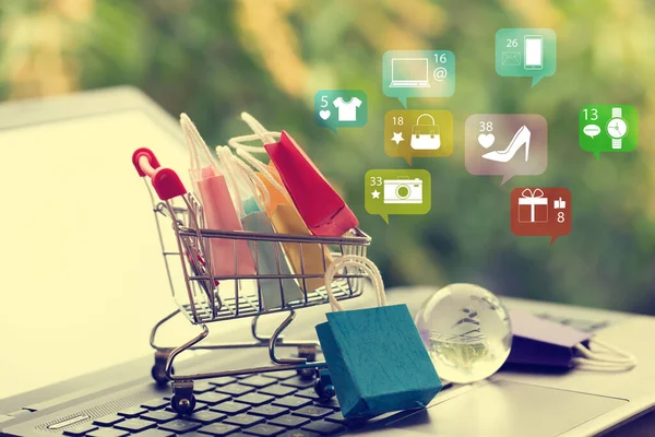 Çevrimiçi alışveriş, e-ticaret ve müşteri deneyimi kavramı: Bir tramvayda kağıt alışveriş poşetleri veya klavyede alışveriş arabası.