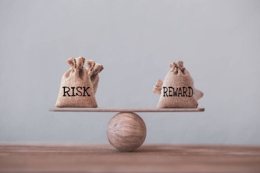 Temel denge ölçeğinde aynı pozisyonda risk ve ödül torbaları. Risk yönetimi konsepti, yatırımcıların beklenen bir yatırımın geri dönüşünü karşılaştırmak için risk ödül oranı kullandıklarını gösteriyor