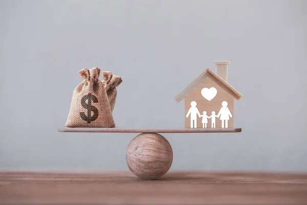 Ev kredisi ve aile finans yönetimi kavramı: ahşap ev ve kalp, aile üyesi ve Amerikan dolarları denge ölçeğinde. Konut satın almak için harcamaları hazırlayın.