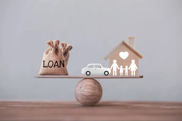 Loan bags with family member and car in a house on balance scale. Concept family financial management, mortgage and payday loan or cash advance.