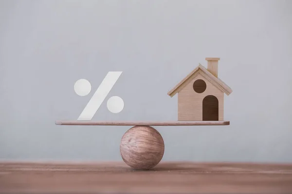 Sembol simgesi ve ev ölçeği eşit konumda. Finansal yönetim kavramı: kısa vadeli bir konut kredisini tasvir eder.