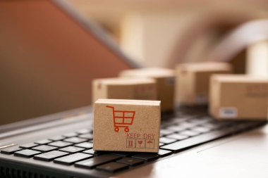 İnternetten alışveriş, e-ticaret konsepti: klavyedeki karton kutular. çevrimiçi internet kullanılarak kolayca yapılabilen ulaşım tasvirleri.
