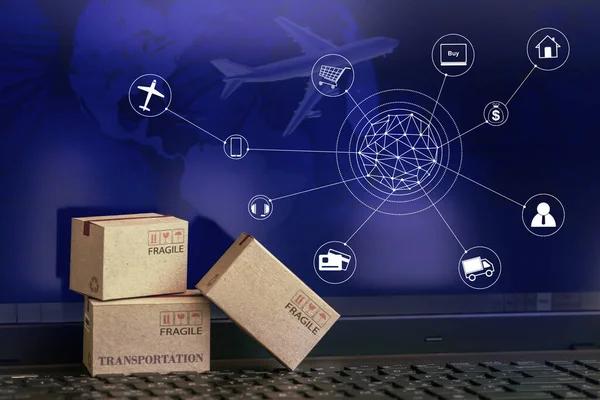 Bilgisayarın arka planında ürünleri paketleyen karton kutular. Ulaşım, küresel taşımacılık ya da uluslararası taşımacılık, denizaşırı ticaret konsepti. çevrimiçi alışveriş kavramı.