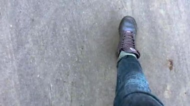 Kot pantolon ve spor ayakkabılı bir adam yol boyunca yürüyor, birinci şahıs manzarası
