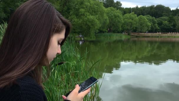 Schöne Mädchen Park See Tippt Eine Nachricht Das Smartphone — Stockvideo